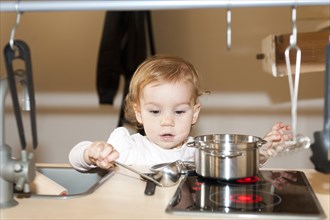 Little girl playing in a children's kitchen