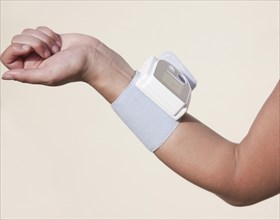 Forearm of a woman with an attached blood pressure monitor