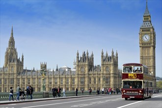 Red double-decker sightseeing bus travelling on Westminster Bridge with Big Ben or Elizabeth Tower