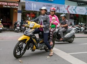 Two women with child on a motorcycle