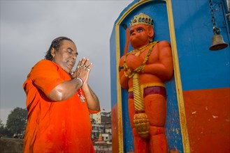 A devotee is praying in front of a Hanuman statue