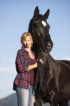 A young woman with a black Hanoverian horse
