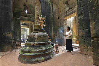 Cambodian with incense sticks in front of Stupa
