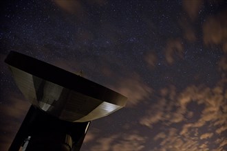 Satellite earth station in front of the night sky