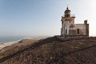 The abandoned lighthouse Farol de Morro Negro on the black mountain 'Morro Negro' on the east coast of the island of Boa Vista