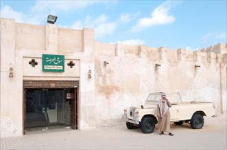 Traditionally dressed man standing next to a pickup truck