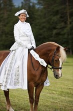 Equestrienne wearing a Venetian costume riding a Welsh Cob