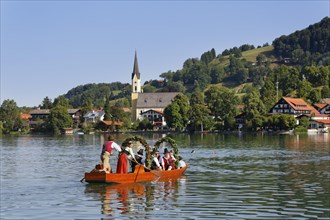 Locals wearing traditional costumes in decorated wooden Platte boats