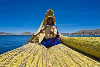 A local woman rowing a traditional boat made of totora reeds on Lake Titicaca