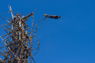Man jumping from a bamboo tower