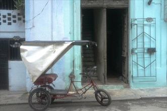 Bicycle rickshaw parked in front of the entrance of a building