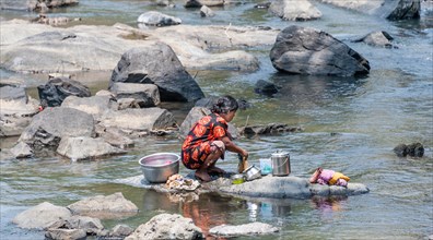 Indian woman washing clothes in a river