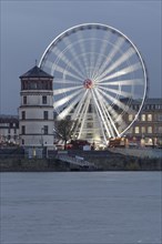 Rheinfront promenade with Schlossturm tower and an illuminated ferris wheel
