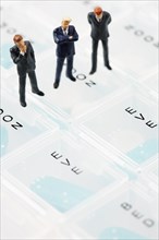 Businessmen miniature figurines on pill box