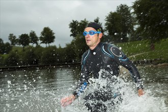 Triathlete running through water
