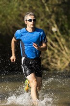 Jogger running through a stream