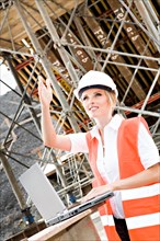 Young female constructor at building site of a new motorway