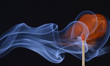 Lit matchstick with a flame and smoke