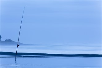 Fishing rod on the beach at dusk