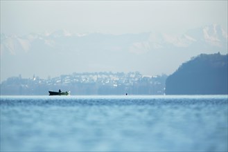Fishing boat on Lake Constance with the Alps at back
