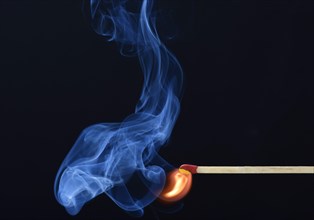 Lit matchstick with a flame and smoke