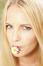 Woman with a daisy in her mouth