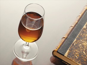 Glass of sherry beside an old book