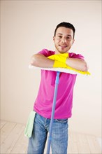 Smiling man leaning on a mop