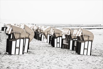 Roofed wicker beach chairs on the beach