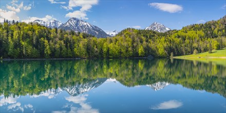Mountains with snow remains are reflected in Alatsee