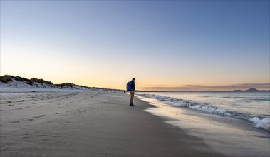 Young man walking along the beach