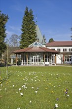Historic Kurhaus with a pavilion and crocuses in the lawn