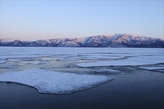 Early morning mood on the frozen Lake Kussharo with ice floes in the front