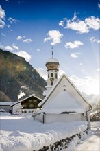 Snow-covered church and sun rays