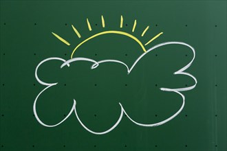 Cloud with a sun drawn with chalk on a blackboard