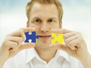 Man putting pieces of a jigsaw puzzle together