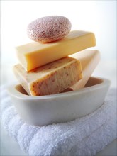 Bars of hand-made soaps piled in a soap dish
