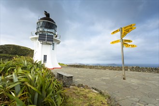Signpost with distances and lighthouse at Cape Reinga