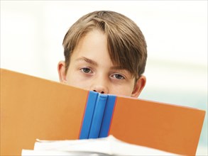 Schoolboy behind a school book