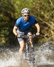 Mountain biker crossing a stream