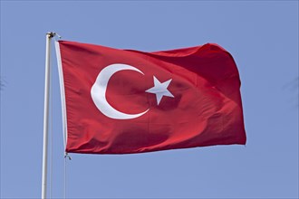 Waving Turkish flag in front of blue sky