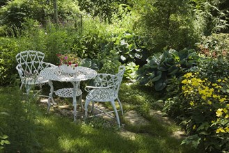 White metal garden table and chairs in a residential backyard