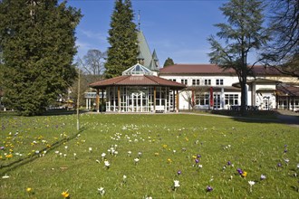 Historic Kurhaus with a pavilion and crocuses in the lawn