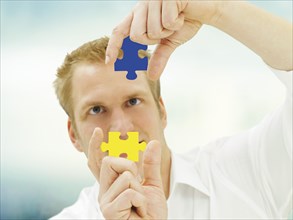 Man putting pieces of a jigsaw puzzle together