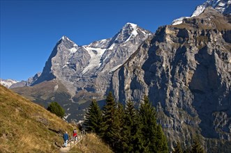 Hikers at the foot of Eiger and Moench Mountains and Eiger glacier