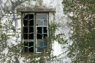 Broken window of an abandoned house in an abandoned village