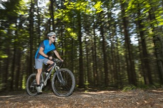 Cyclist on a mountainbike riding through a forest