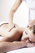 Young woman having her back massaged by a therapist