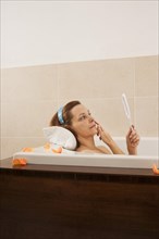 Woman checking her expression lines while bathing