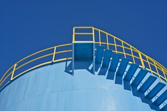 Yellow railings of a blue silo